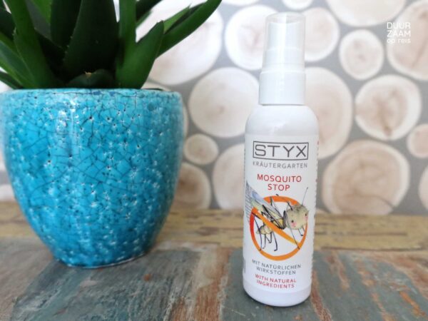 Natuurlijke muggenspray STYX: flesje muggenspray staat naast een kamerplantje