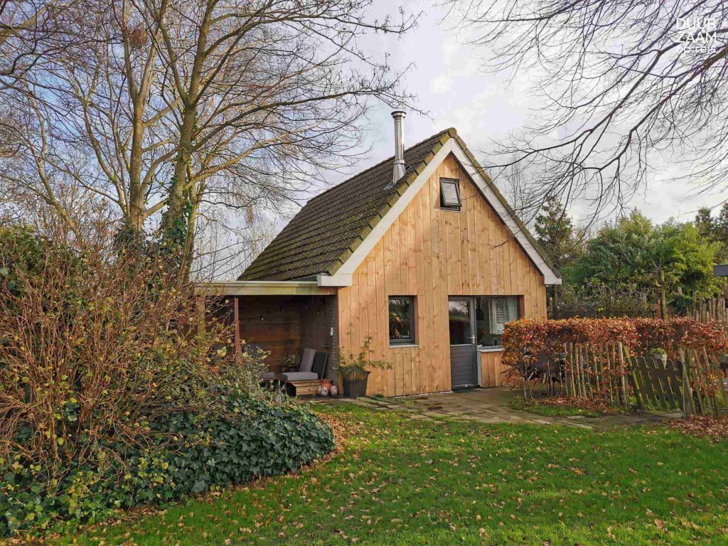 Duurzame accommodatie Natuurhuisje: bungalow met houten voorkant in de herfst